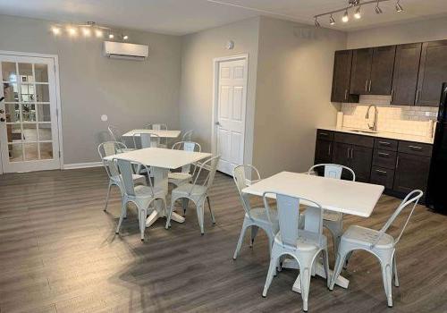 A community kitchen at Crossings at Stanbridge apartments for rent with two tables and chairs